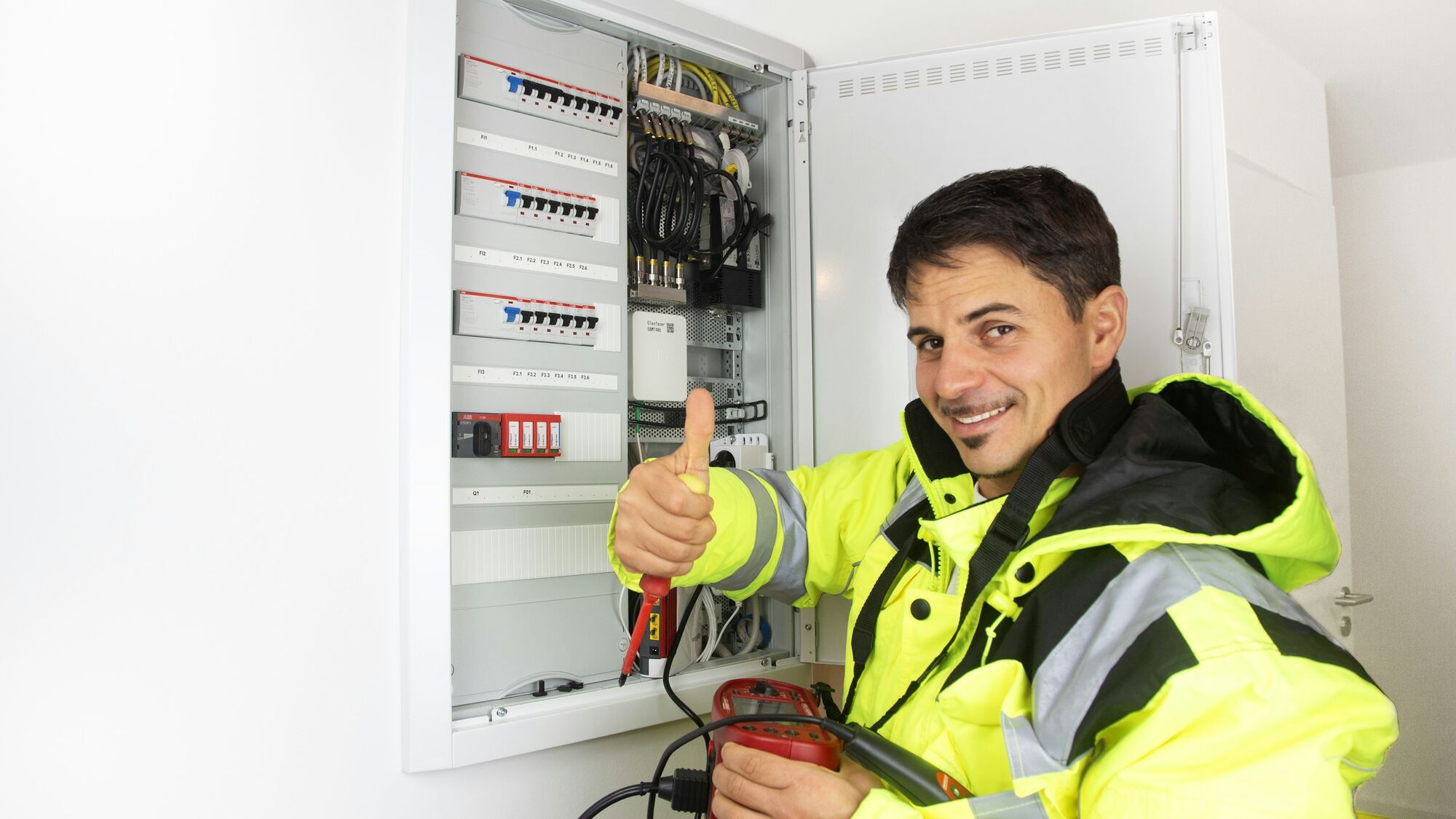 Engineer performing NFPA 70B compliance testing and inspection inside a healthcare facility electrical room